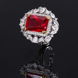 Macro shot of large rectangular red ruby with marquise cut stones on black reflection