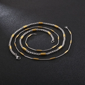 Modern two-tone stainless steel box chain necklace with golden cylindrical accents on black