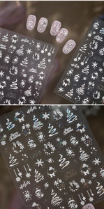 Macro shot of 5D white embossed Christmas nail stickers with snowflakes and trees