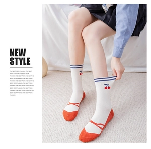 Close-up of cotton cherry socks with ballet style ribbon design and white fabric texture