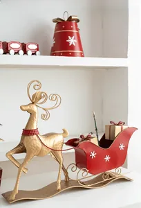 Detail of a golden metal reindeer with a red snowflake sleigh for Christmas decor