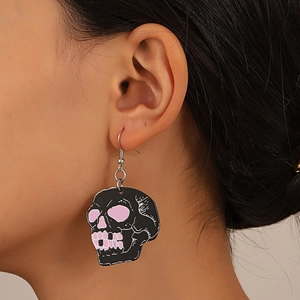 Close-up of a skull earring with pink accents worn by a model for a stylish Gothic look