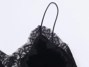 Detailaufnahme der feinen schwarzen Spitze und dünnen Träger am Samtkleid
