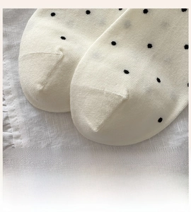 Detail of seamless toe and black polka dot pattern on beige cotton ankle socks