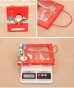 Detail view of red Christmas stationery set box with scale showing 57g weight measurement