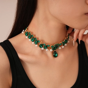 Vintage gold layered necklace with green water drop gems and white pearls on a model