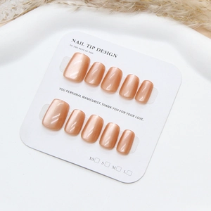Handmade amber cat-eye press-on nails in short square shape on display card