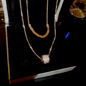 Detail of 18k gold plated double layer necklace with cubic zirconia cylinder pendant