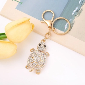 Detailed top view of a gold turtle keychain with sparkling rhinestones and lobster clasp