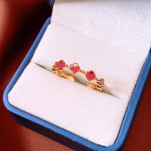 Détail d'une bague plaquée or 18k avec cœurs en émail rouge et zircon dans un coffret bleu