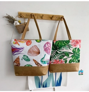 Canvas and jute tote bags with seashell and tropical plant prints on wooden hooks