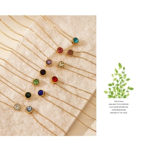 Macro view of multi-color round crystal pendants on fine gold-plated stainless steel chains