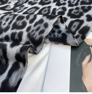 Close-up of soft leopard print scarf texture with thick black and grey cashmere-like fabric
