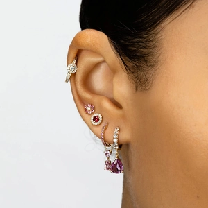 Detailed view of layered ear jewelry set with pink flower studs and colorful zircon drops