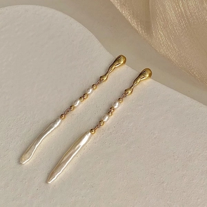 Pendientes largos dorados con perlas barrocas irregulares y borlas elegantes