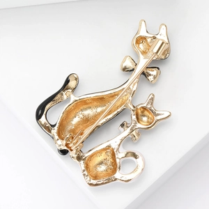 Detail view of the polished gold metal back and secure pin clasp on the cat brooch