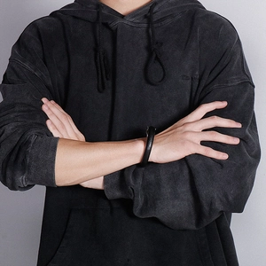 Detail of a men's punk wolf head leather bracelet with black scale texture on a model