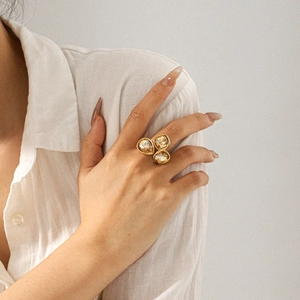 Detail of 18k gold plated stainless steel ring with three amber crystals on a model