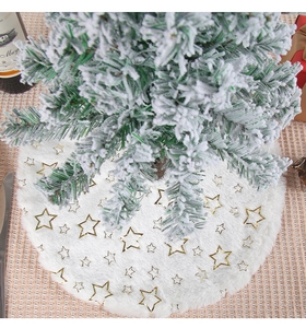 Detail of plush white Christmas tree skirt featuring shiny gold foil star patterns