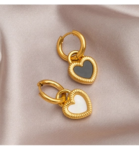 Detail of heart-shaped titanium steel earrings with black and white shell inlays on silk