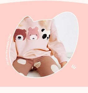 Detailed view of pink fleece sweatshirt with animal embroidery and polka dot pants