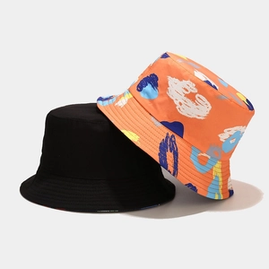 Reversible bucket hat in solid black and colorful graffiti print for outdoor sun protection