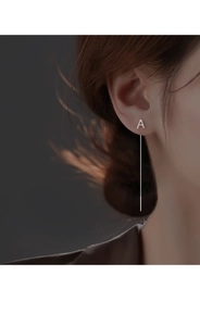 Close-up of minimalist silver letter A threader earring with long tassel on model