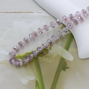Detail of 6mm amethyst crystal faceted wheel beads and seed beads for jewelry making