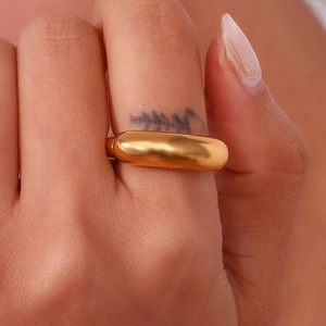 Macro shot of minimalist 18K gold plated wide band ring with smooth metallic texture