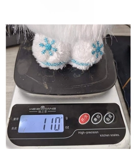 Weight measurement of white snowflake gnome plush doll showing 110g on a digital scale