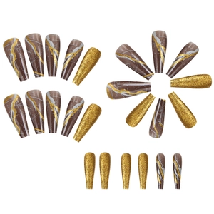 Detail of long coffin press-on nails featuring brown marble pattern and gold glitter finish