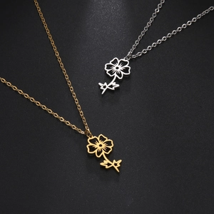 Detailed view of hollow floral pendants in gold and silver stainless steel finishes