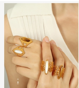 Detail of vintage bohemian gold ring set with tiger eye stone and white shell inlay