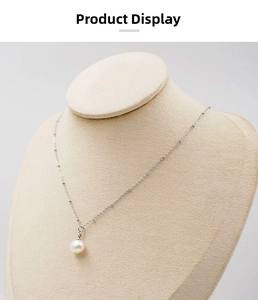 Detailed view of single freshwater pearl pendant on a beaded silver chain necklace