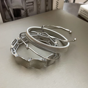 Detailed close-up of 4-piece silver metal bracelet set with chain and twisted designs