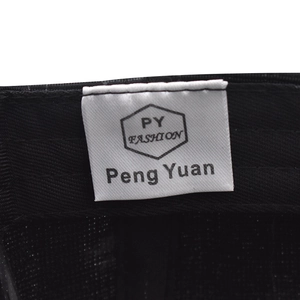 Macro detail of the woven inner lining and washing label of the black baseball cap