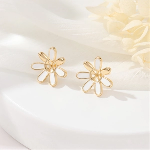 Close-up of elegant camellia flower stud earrings with white petals and gold trim