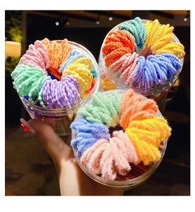 Close-up of colorful elastic hair bands and plush ties in clear plastic jars
