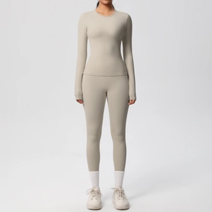 Dettaglio top yoga beige a maniche lunghe e leggings a vita alta in tessuto spazzolato
