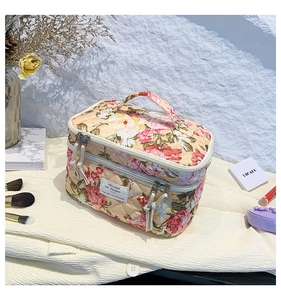Detailed macro of floral quilted makeup bag with gold zipper and cotton fabric texture