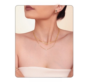 Close-up of double-layer gold necklace set with pentagram zircon charms on a model