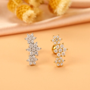 Details von gold- und silberfarbenen Blumen-Ohrsteckern mit funkelnden Zirkonia-Steinen