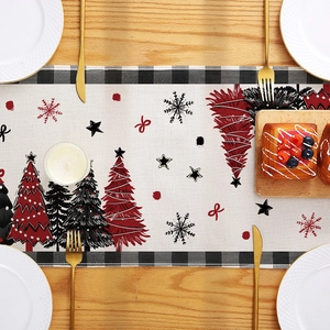 Christmas table runner with red trees and snowflakes on rustic wooden dining table