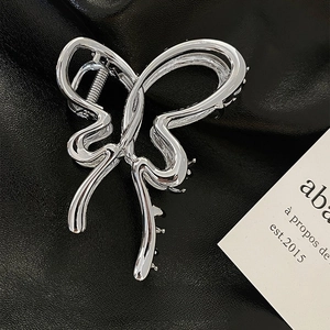 Close-up of a silver butterfly hair claw clip with 11cm length on black leather