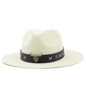 Detail of bohemian straw hat featuring a faux leather band and metallic bull skull emblem