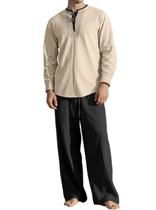 Detail of men's linen long sleeve shirt with embroidery and loose black trousers