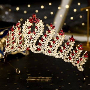 Macro shot of detailed golden bridal crown with red crystals and shimmering rhinestones