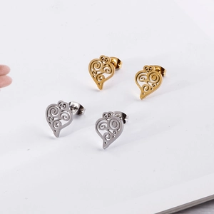 Macro detail of gold and silver filigree heart stud earrings with intricate openwork