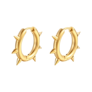 Detail of gold huggie hoop earrings with punk spike rivets on white background