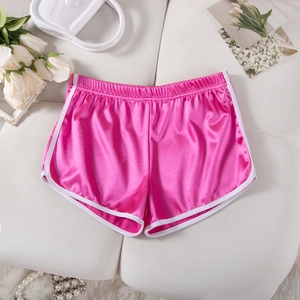 Detail of rose pink satin sports shorts with white trim on a soft beige background